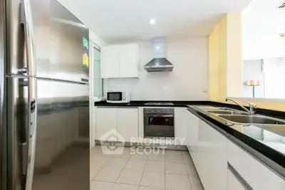 Modern kitchen with stainless steel appliances and sleek white cabinetry.