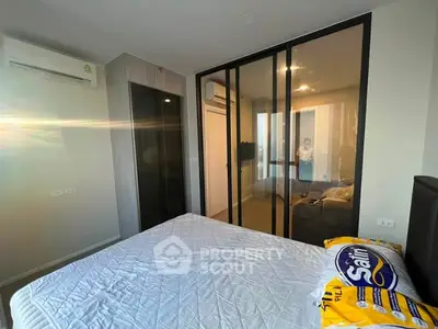 Modern bedroom with glass wardrobe and air conditioning, featuring a stylish bed setup.