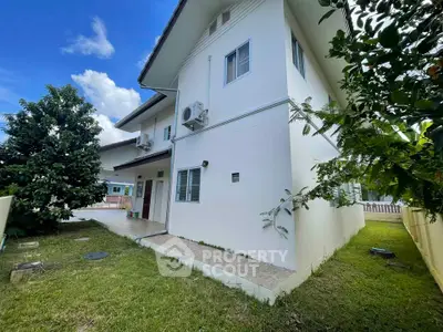 Charming two-story home with lush garden and modern exterior design, perfect for family living.