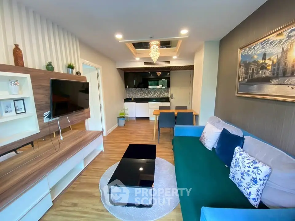 Modern living room with stylish decor and open kitchen layout, featuring elegant lighting and cozy seating area.