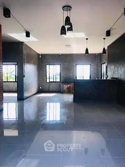 Spacious modern living room with sleek flooring and stylish lighting fixtures.