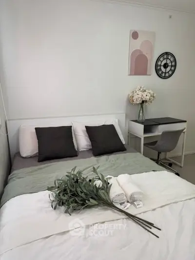 Cozy bedroom with modern decor, featuring a comfortable bed, stylish desk, and elegant wall art.