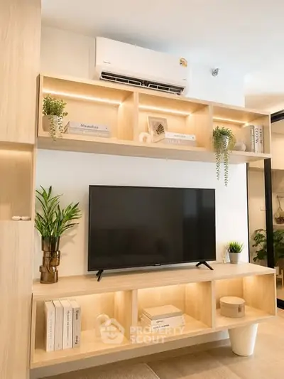 Modern living room with stylish wooden shelves, TV, and air conditioning unit, perfect for cozy urban living.