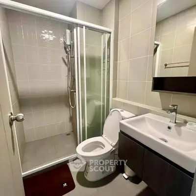 Modern bathroom with glass shower and sleek fixtures in a contemporary apartment.