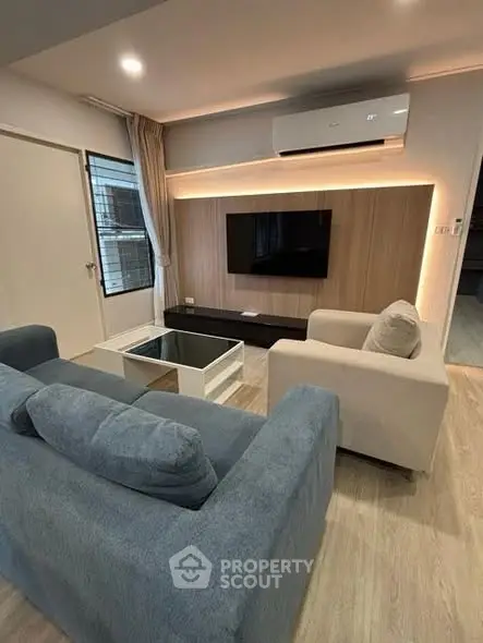 Modern living room with stylish furniture and wall-mounted TV