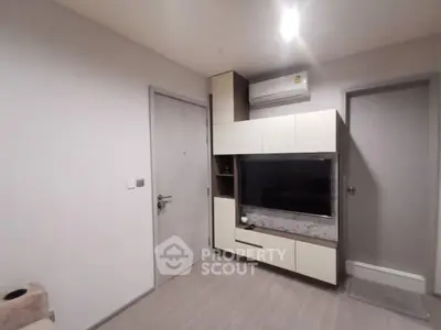 Modern living room with sleek TV unit and air conditioning in a cozy apartment.