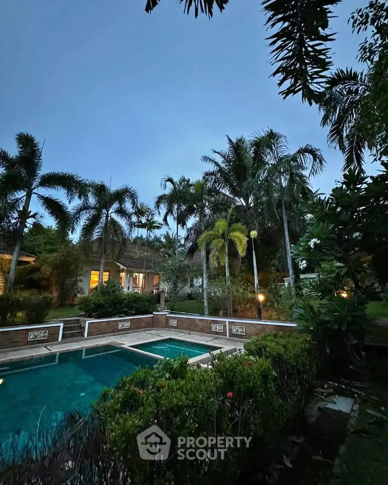 Luxurious tropical villa with stunning pool and lush garden at dusk