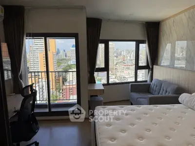 Modern bedroom with city view, featuring large windows and stylish decor.