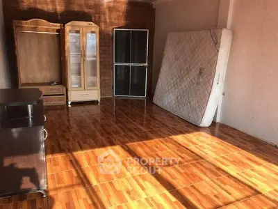 Spacious room with wooden flooring and minimal furniture, perfect for customization.