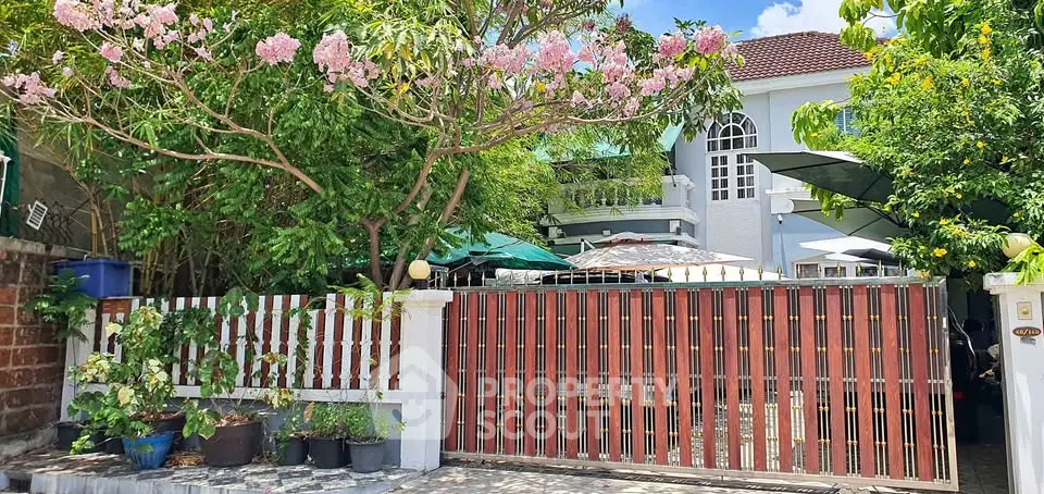 Charming residential property with lush garden and secure gated entrance, perfect for family living.