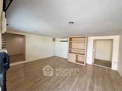 Spacious room with wooden flooring and built-in shelving, ideal for versatile living space.