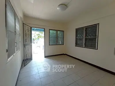 Spacious unfurnished room with tiled flooring and large windows, perfect for customization.