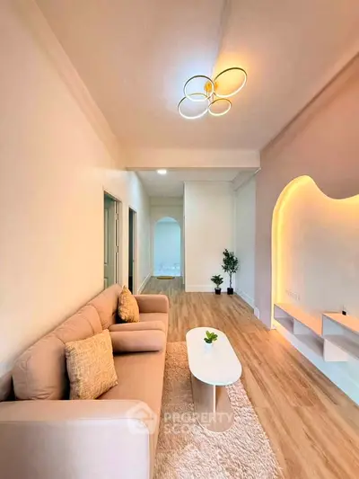 Stylish living room with modern lighting and cozy seating in a contemporary apartment.