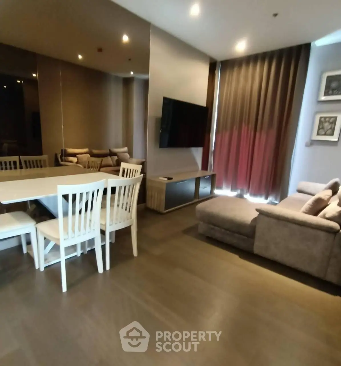 Modern living room with cozy seating and dining area, featuring elegant decor and ambient lighting.