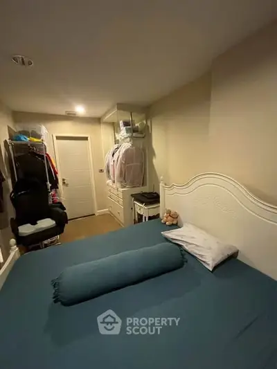 Cozy bedroom with elegant white bed frame and organized closet space