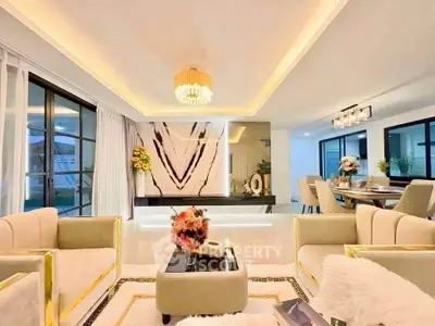 Luxurious open living and dining area with elegant decor and modern lighting.