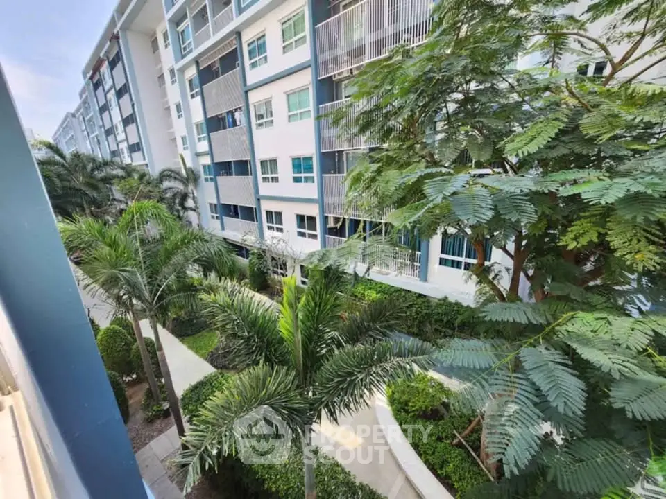 Modern apartment building with lush garden view and palm trees