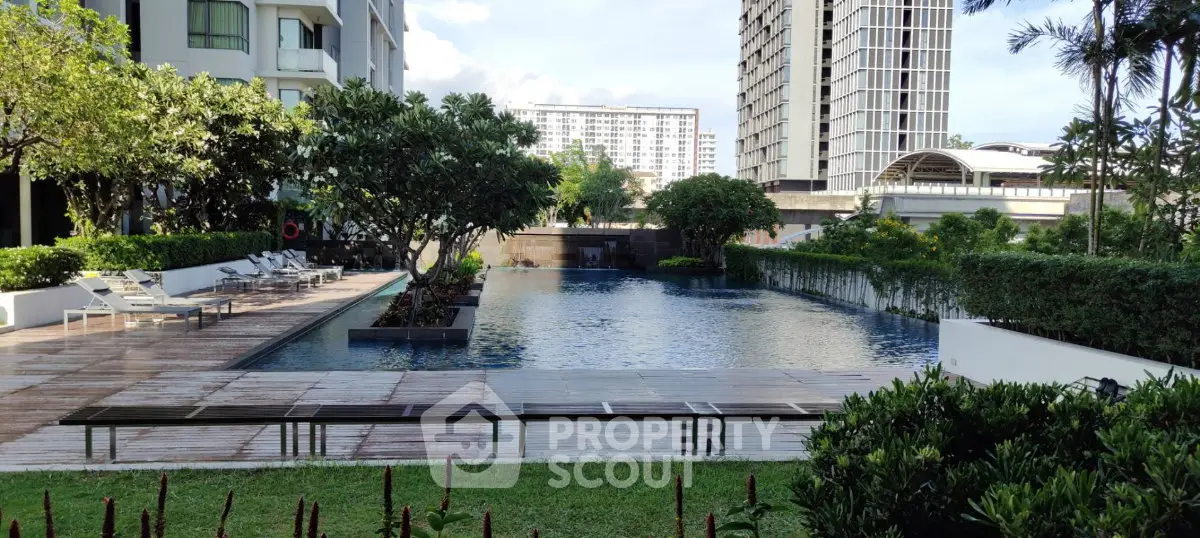 Luxurious residential pool area with lush greenery and modern architecture.