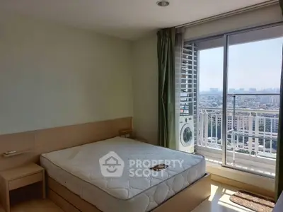 Spacious bedroom with city view and balcony access in modern apartment.