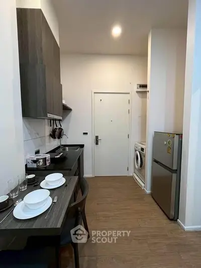 Modern kitchen with dining area, sleek cabinetry, and integrated appliances in a compact layout.