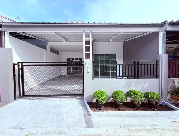 Modern home exterior with gated entrance and small garden, perfect for urban living.