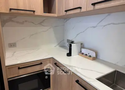 Modern kitchen with sleek marble countertops and built-in microwave