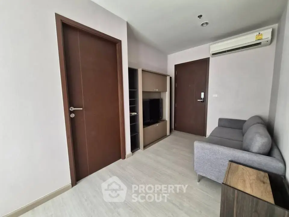 Modern living room with sleek furniture and air conditioning in a contemporary apartment.
