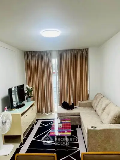 Cozy living room with modern decor and natural light, featuring a comfortable sofa and stylish TV setup.