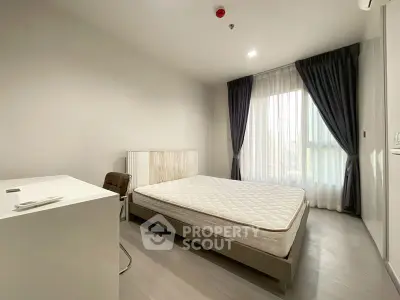 Modern minimalist bedroom with natural light and sleek furnishings.