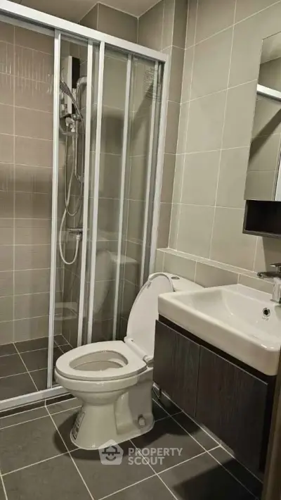 Modern bathroom with glass shower and sleek fixtures in contemporary apartment.