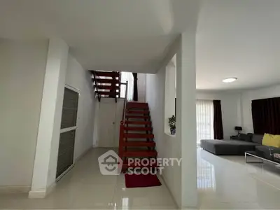 Spacious modern living room with wooden staircase and elegant decor