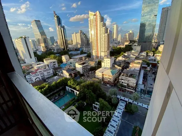 Stunning cityscape view from high-rise balcony overlooking urban skyline and lush greenery.