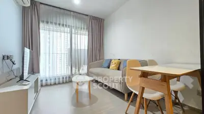 Modern living room with stylish furniture and large window offering natural light.