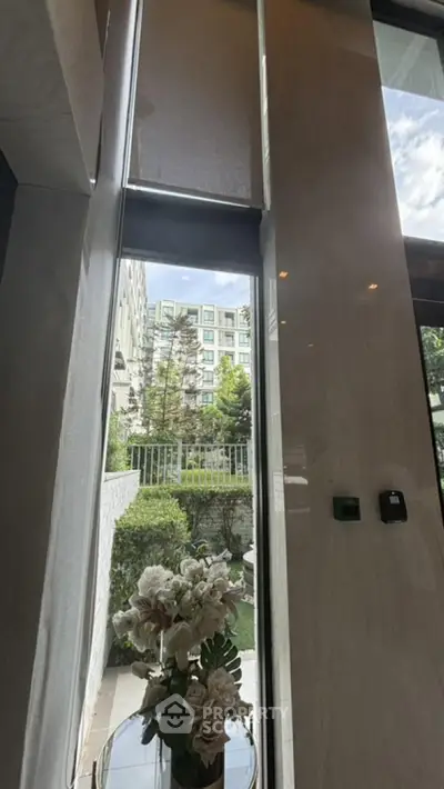 Luxurious high-ceiling window view with elegant decor and garden glimpse