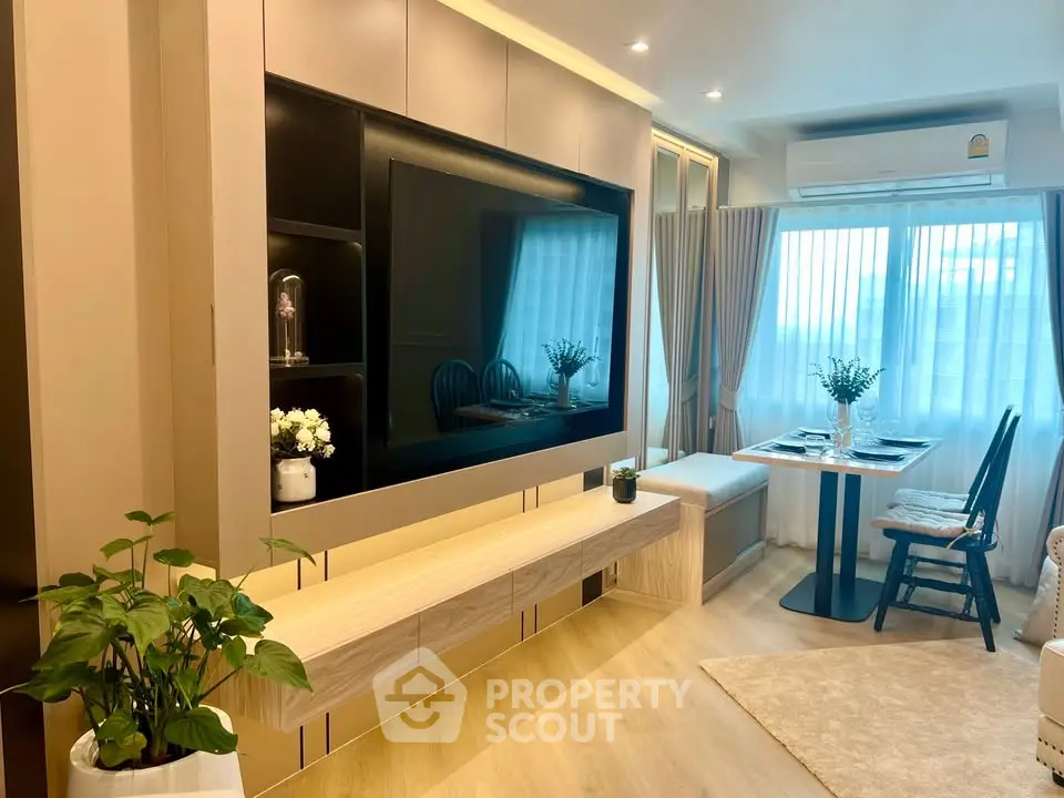 Modern living room with stylish decor and natural light, featuring a cozy dining area and sleek entertainment unit.