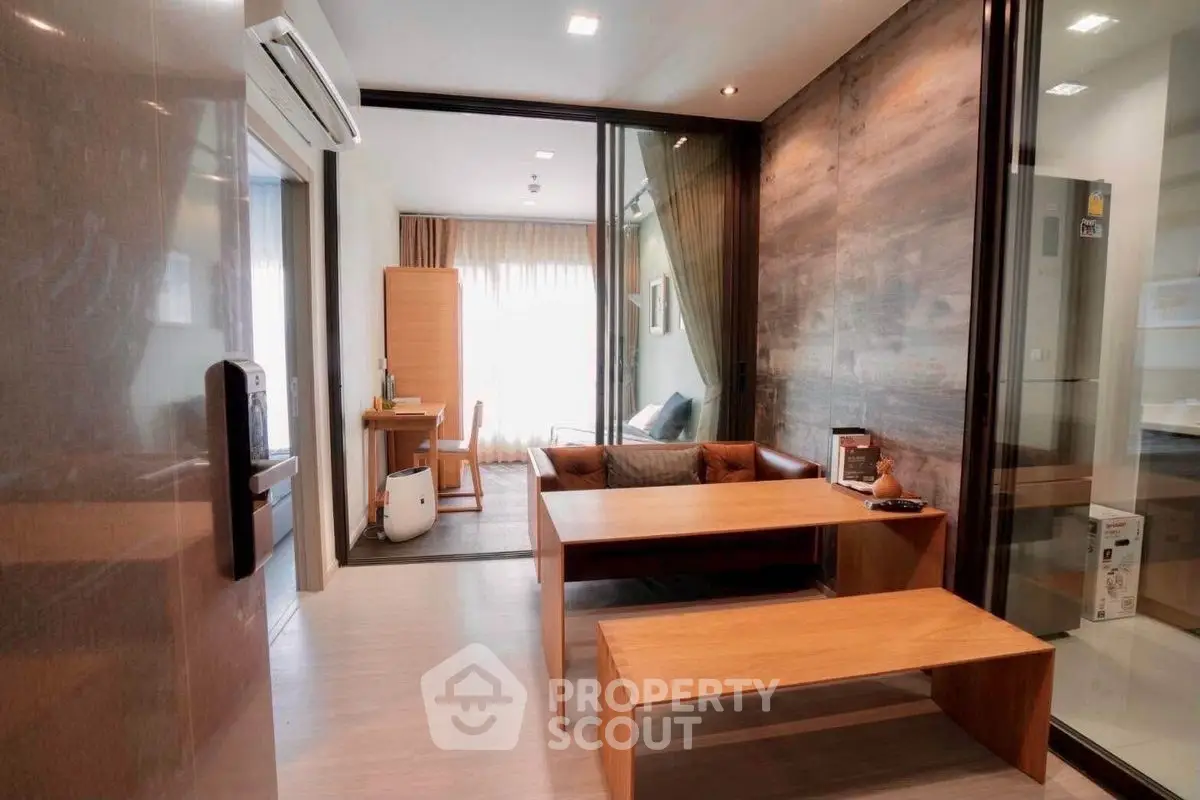 Modern living room with wooden furniture and glass partition, featuring cozy seating area.