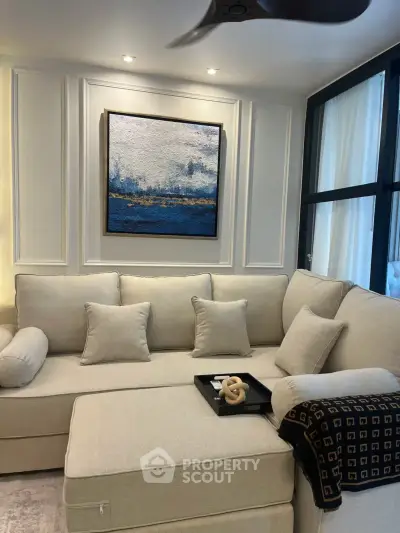 Elegant living room with plush beige sectional sofa and modern art, perfect for relaxation and style.