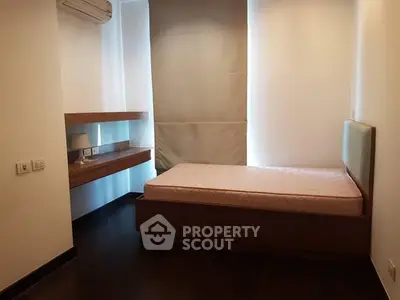 Cozy bedroom with single bed and modern wooden shelves, perfect for minimalist living.