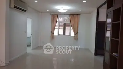 Spacious living room with natural light and elegant curtains, perfect for cozy gatherings.