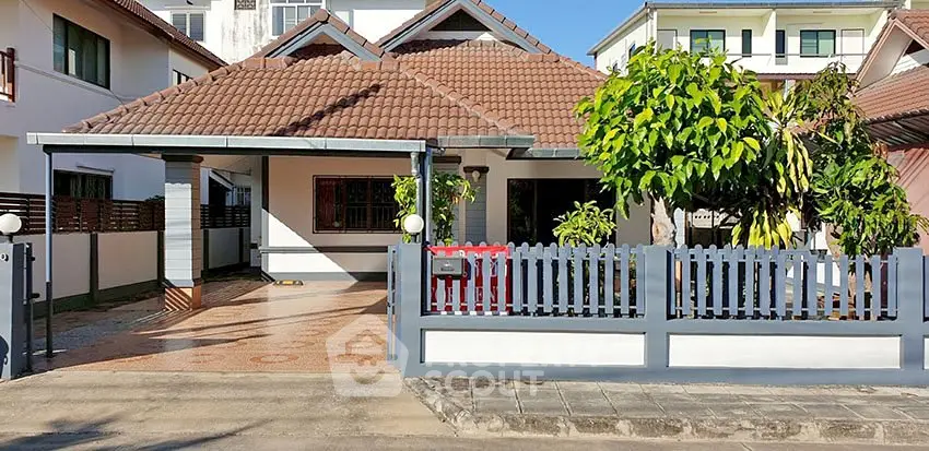 Charming single-story house with tiled roof and spacious driveway in a serene neighborhood.