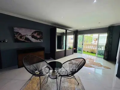 Stylish living room with modern decor and large windows offering natural light and a balcony view.