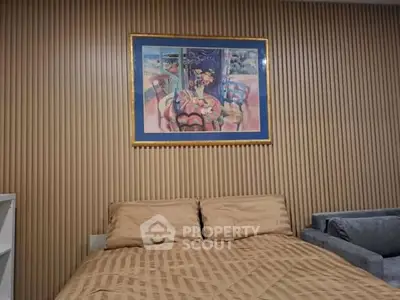 Cozy bedroom with stylish wood paneling and elegant artwork above the bed, creating a warm and inviting atmosphere.