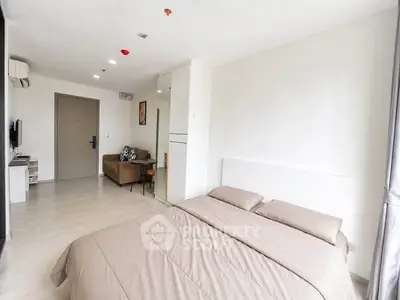 Spacious modern bedroom with cozy living area and minimalist decor