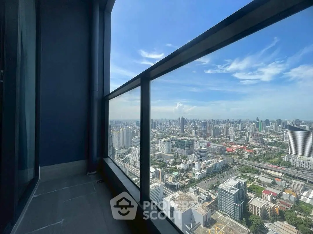 Stunning high-rise balcony view overlooking city skyline with clear blue skies.