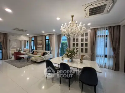 Luxurious open-plan living and dining area with elegant chandelier and modern furnishings.
