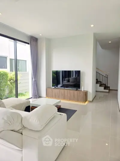 Modern living room with sleek design, large window, and stylish furniture in a bright, airy space.