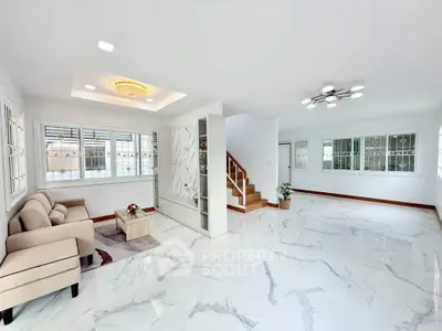 Spacious modern living room with elegant marble flooring and stylish lighting.