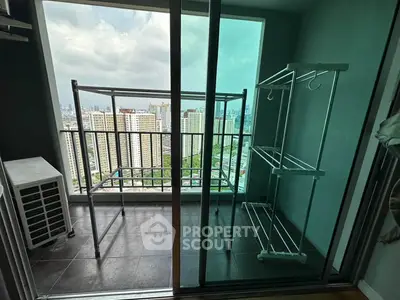High-rise apartment balcony with city view and drying racks, perfect for urban living.
