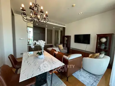 Elegant living room with modern furniture and chandelier, featuring a marble dining table and cozy seating area.