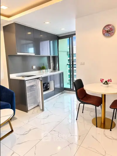 Modern kitchen with sleek cabinets and dining area in a bright apartment
